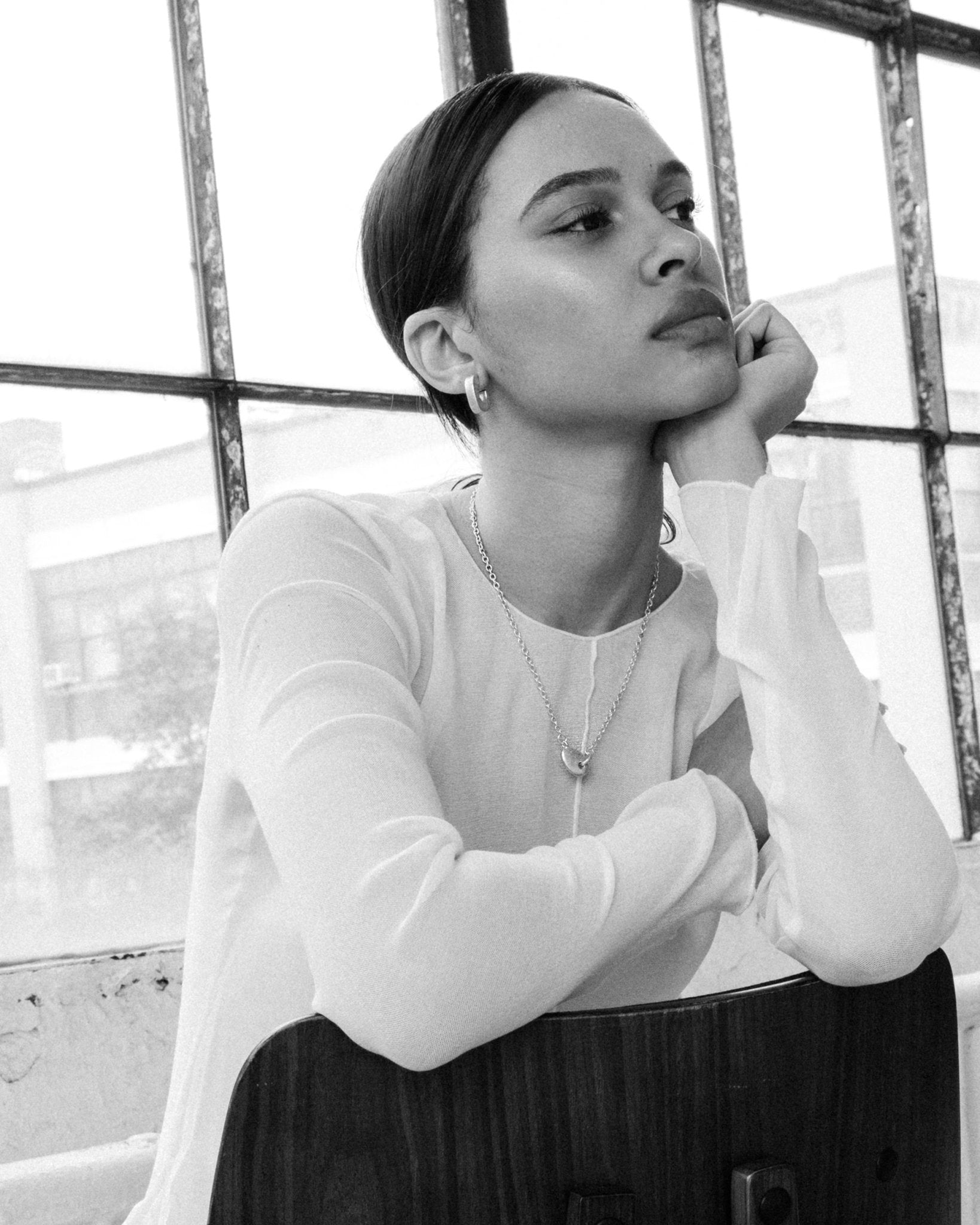 Sculptural silver pendant necklace styled on model’s neck