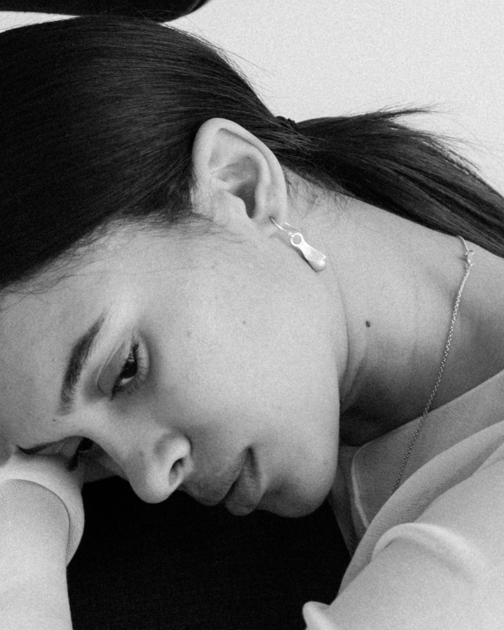 Sculptural silver earrings styled on model’s ear