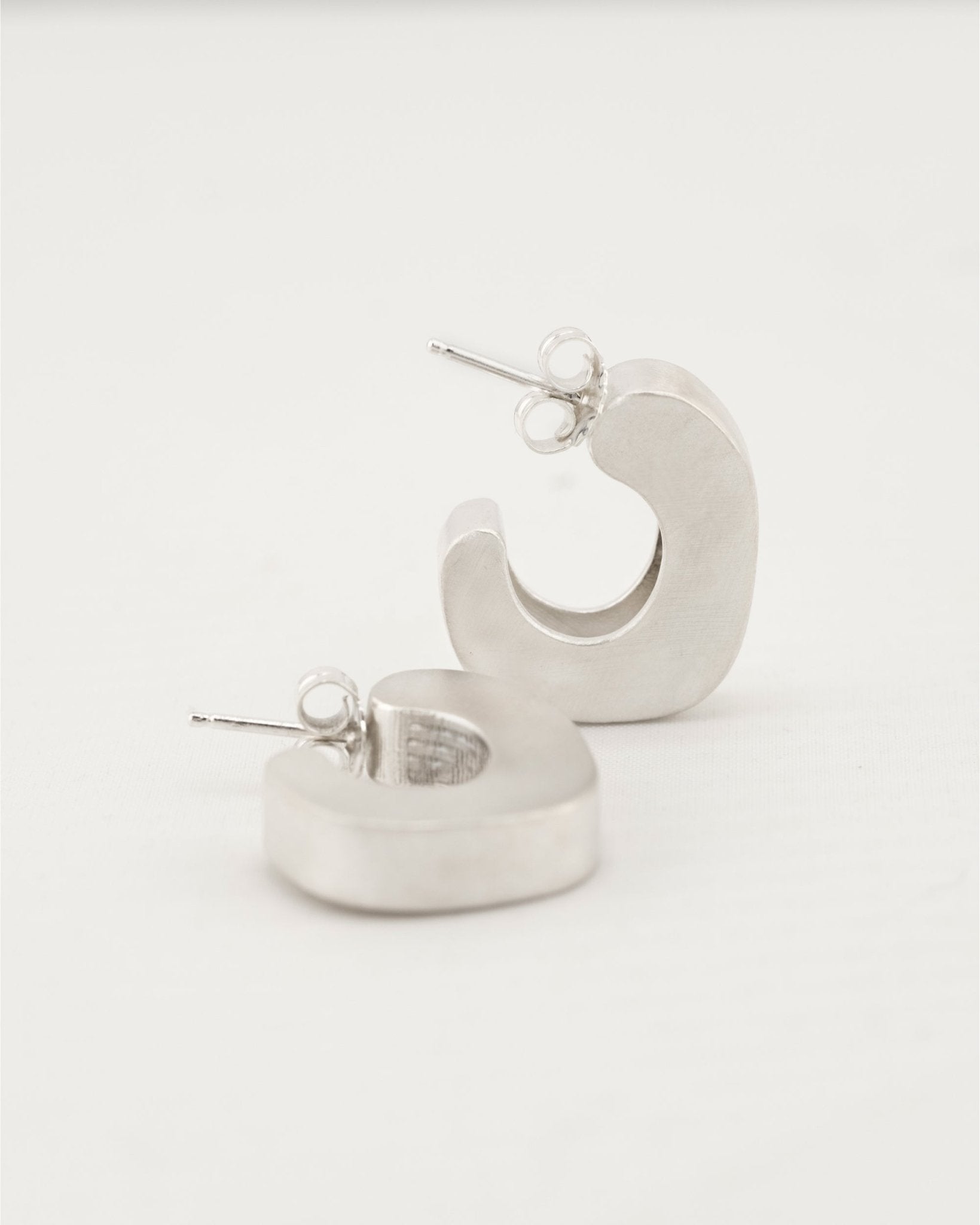 Bold silver hoop earrings with puffy curved design