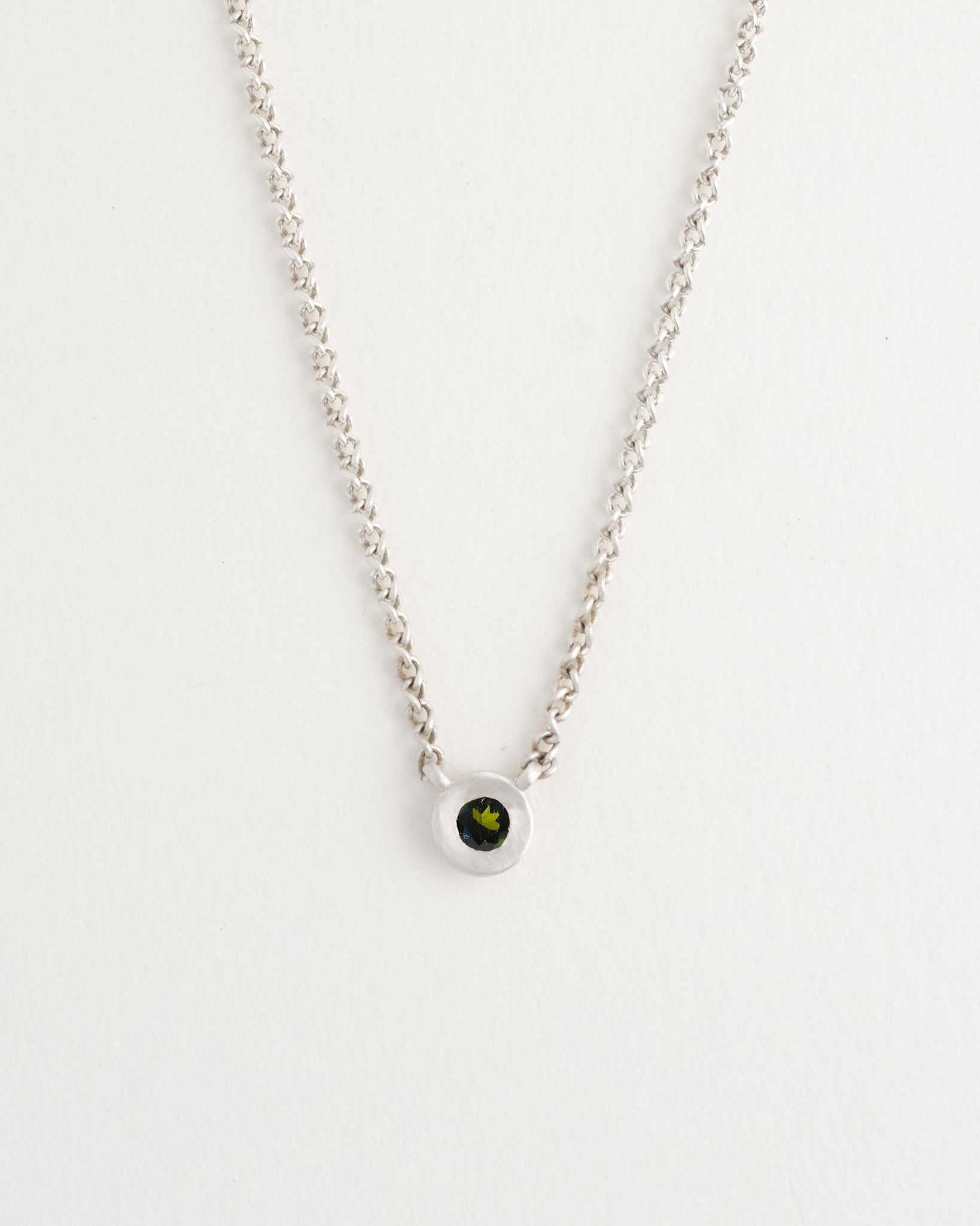 Minimalist silver pendant necklace featuring sapphire