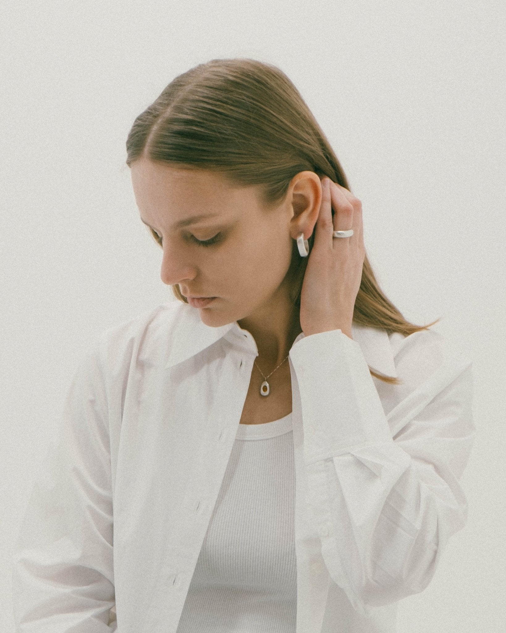CKLASIC sculptural silver band worn stacked with other rings