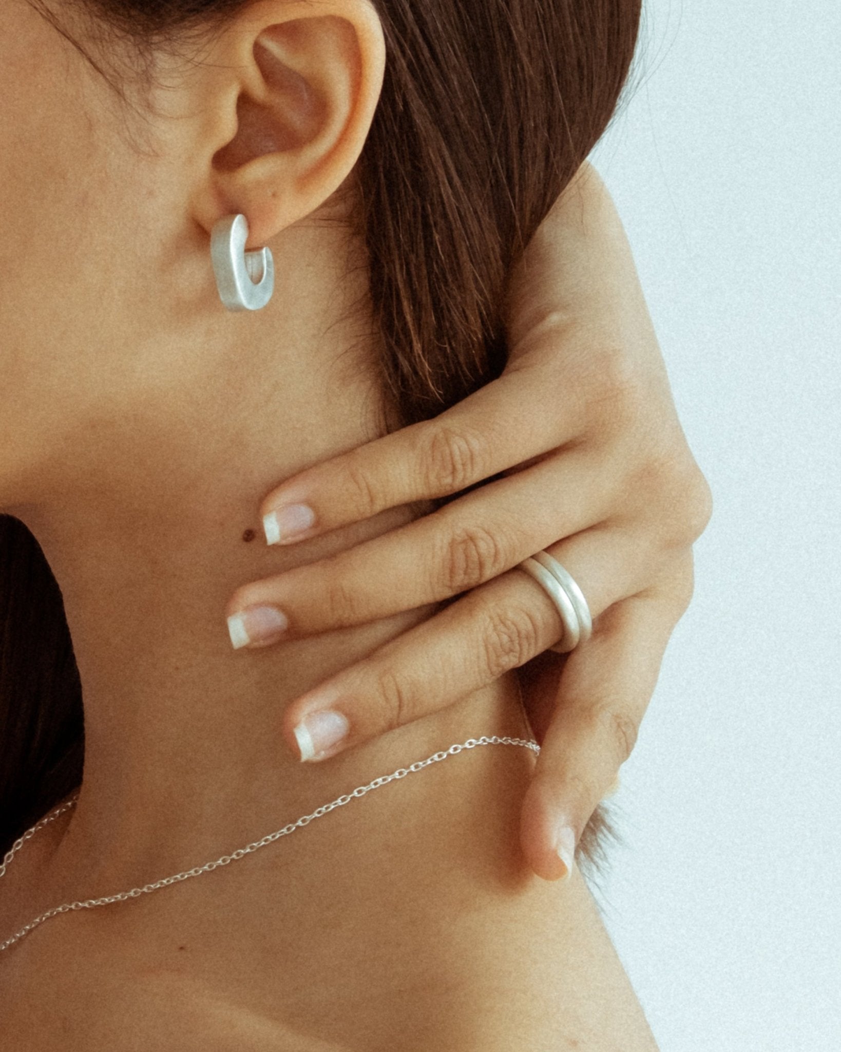 Handcrafted silver jewelry featuring curved sculptural rings
